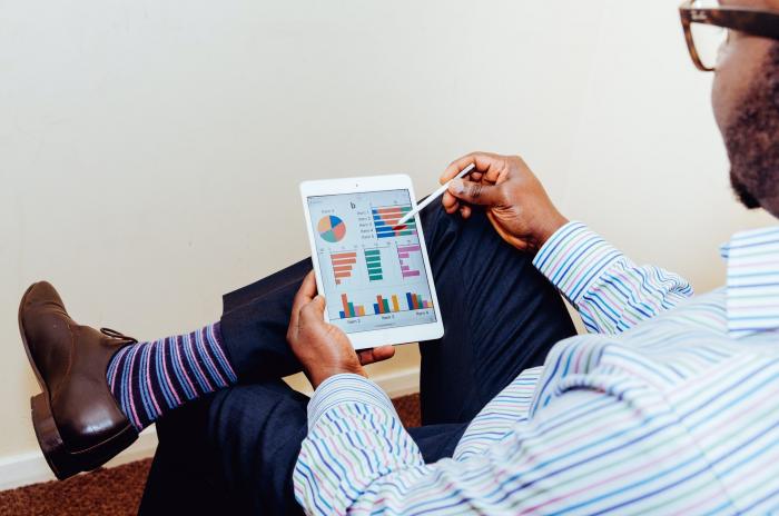 A man is using his tablet to play around with graphs