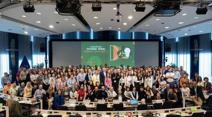 group pictures with a large amount of people in a big room with windows on both sides