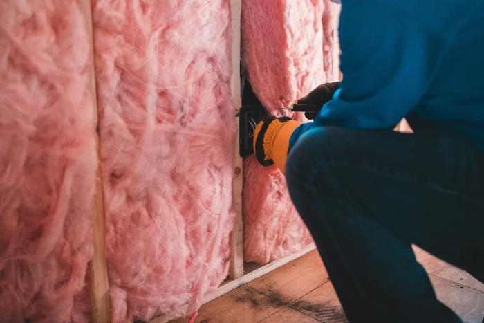Insulation inserted by gloved hands